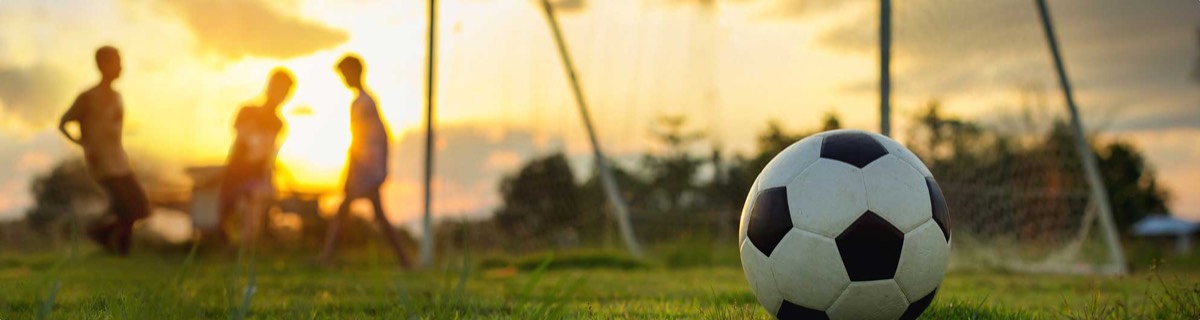 Soccer ball on field at sunset